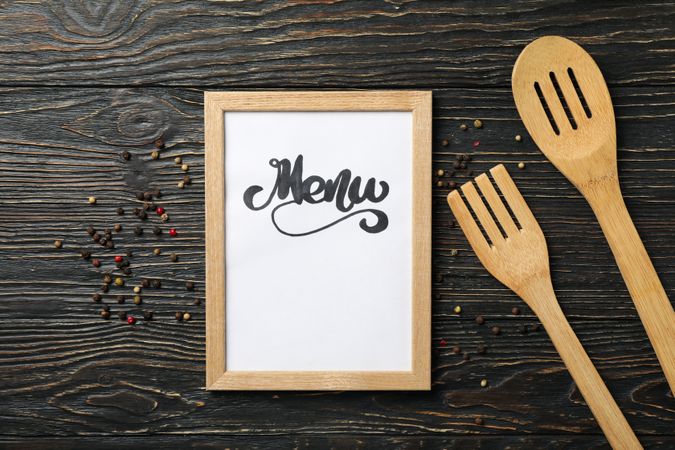 Frame with text Menu and cutlery on wooden background