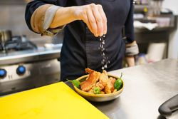 Hand sprinkling salt on famous torreznos of Spanish cuisine