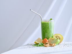 Glass of smoothie near fruits