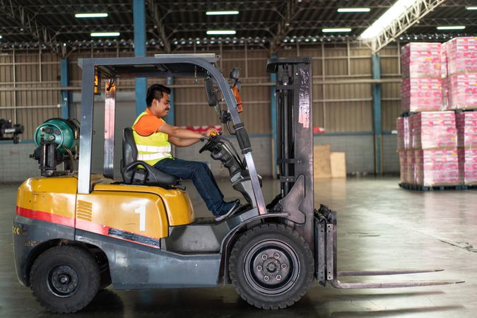 Man driving forklift in factory