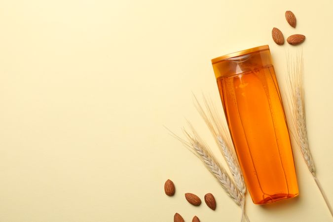Composition with shampoo bottle on beige background, space for text