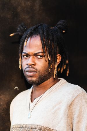 Stylish Black man with dreadlocks in buns