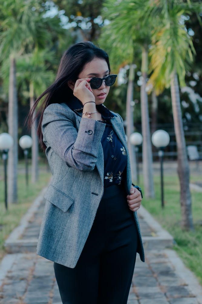 Stylish woman with sunglasses in a park, enjoying a peaceful mom