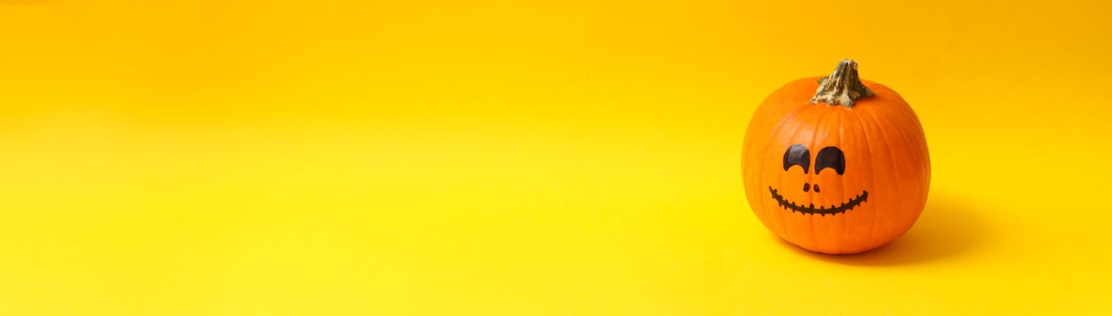 Pumpkins with smiling face on yellow background