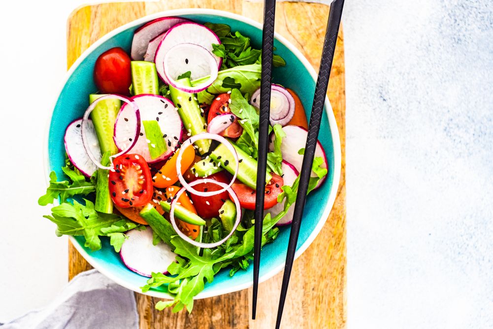 Top view of healthy chopped vegetables salad with chopsticks