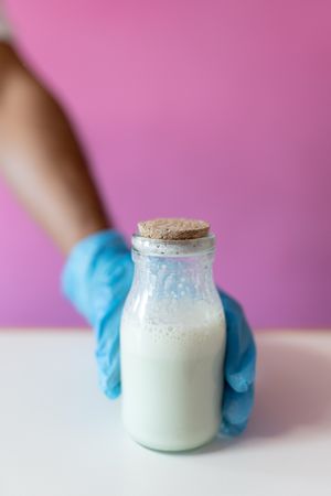 Close up of a worker grabbing a milk jar for making rolled ice cream
