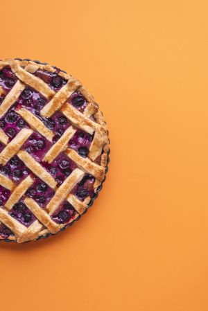 Cut off of blueberry pie on yellow background