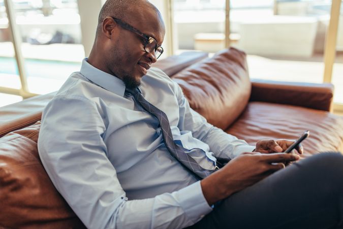 Businessman using mobile phone sitting on a lounge