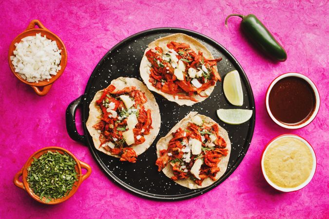 Pepper and lime near tacos al pastor and sauces
