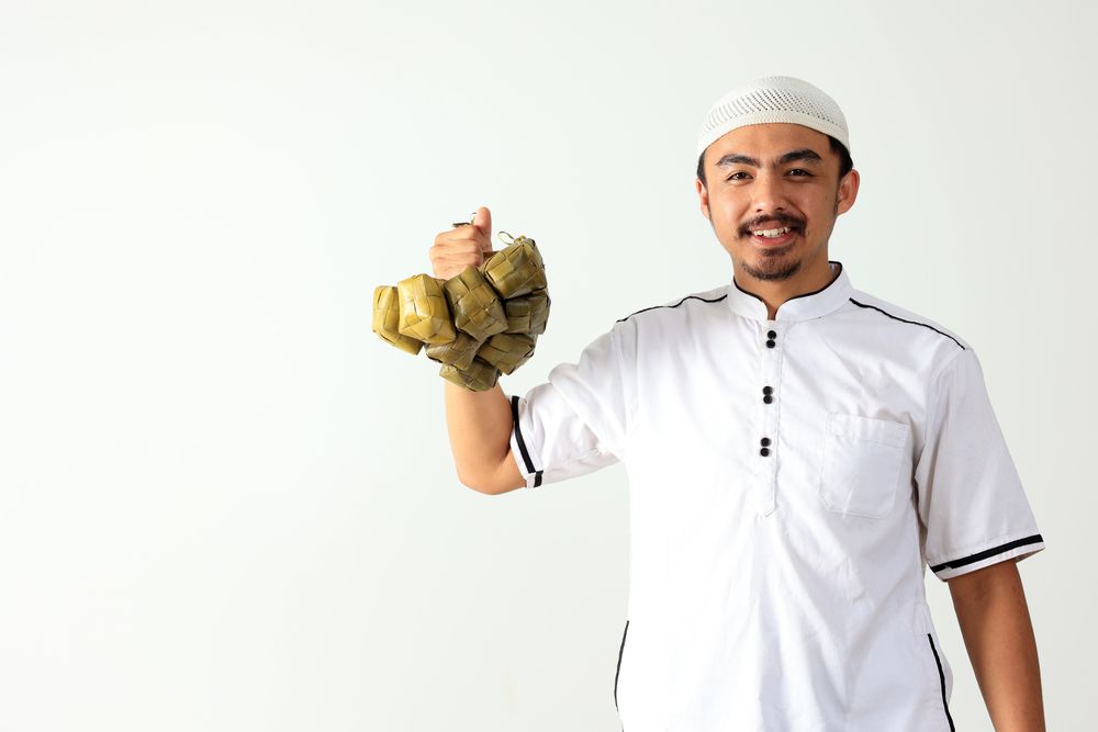 Muslim Male Holding Ready to Eat Ketupat, Rice Cake with Diamond Shape