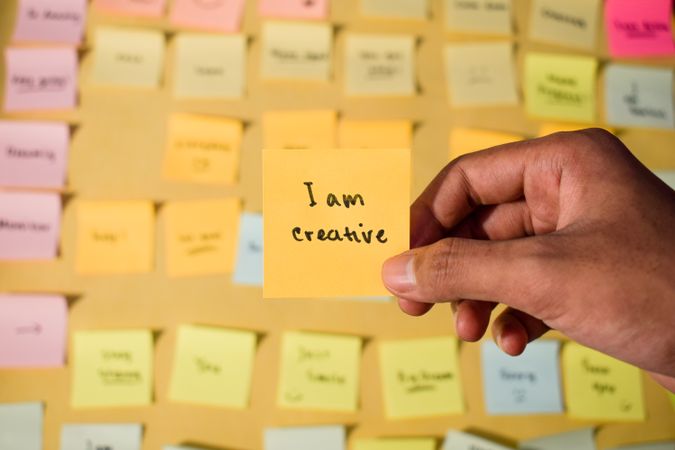 Hand hold sticky notes with words I am creative