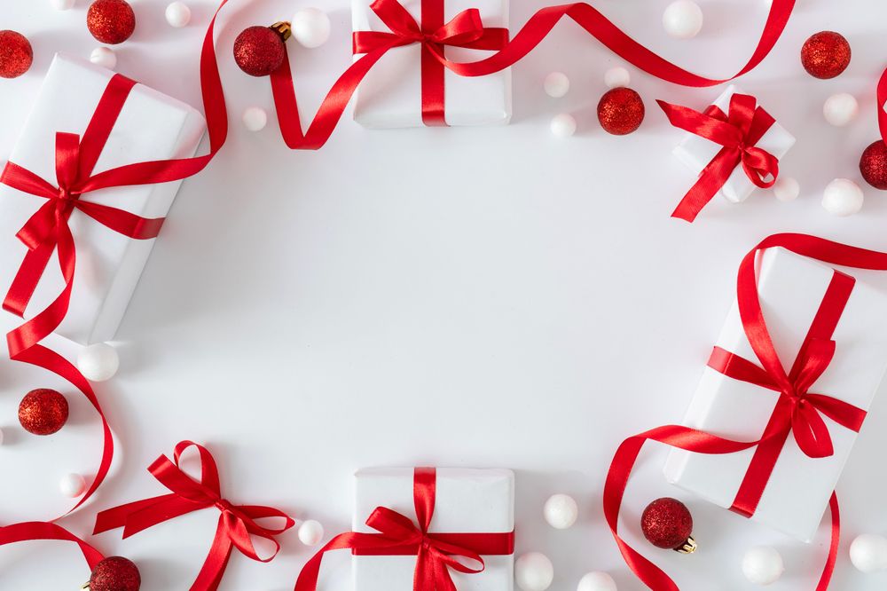 Gift boxes wrapped with red ribbons bordering light background