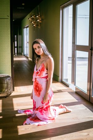 Stylish young woman in dress posing in room