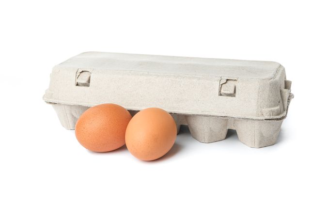 Carton box and chicken eggs isolated on blank background