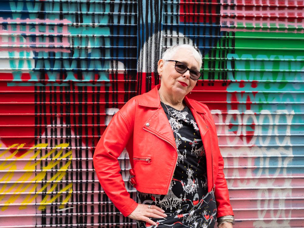 Grey haired woman in red leather jacket with hand on hip