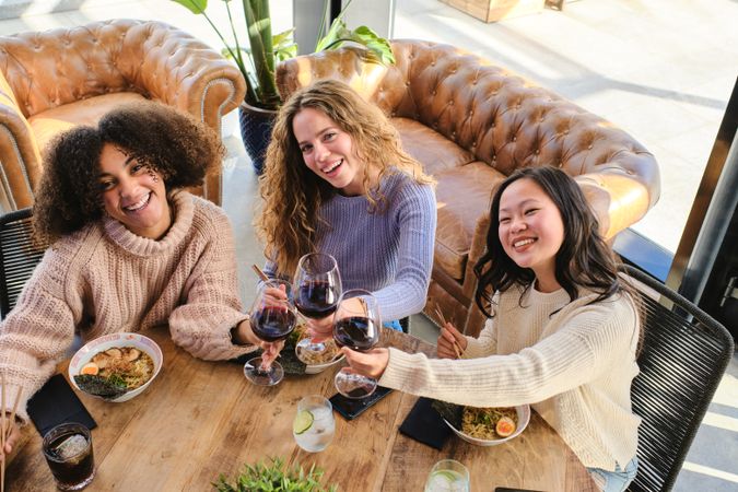Cheerful diverse women with wine and food