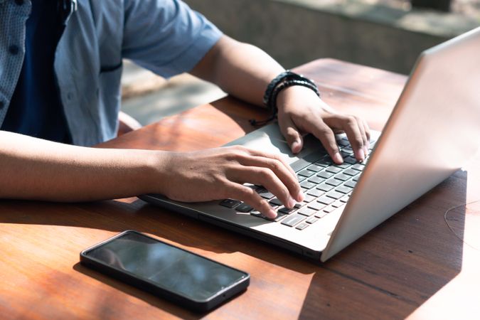 Close Up Asian Young businessman work at outdoor with laptop. Concept of remote and freelance work. Young successful man wearing casual blue cloth.