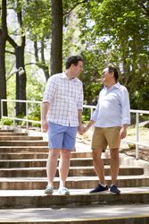 Two men holding hands and getting down outdoor staircase