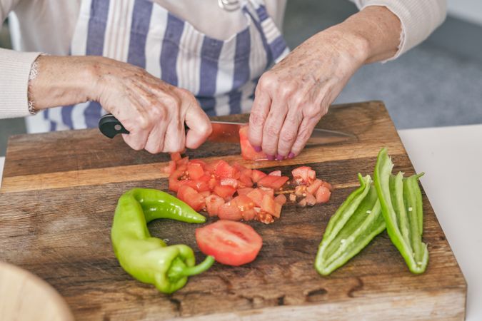 Unrecognizable woman cutting ripe tomatoes