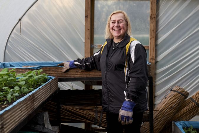 Older woman smiling in greenhouse