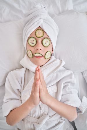 Kid with prayer hands during spa procedures at home