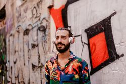Smiling man listening to music and using smartphone