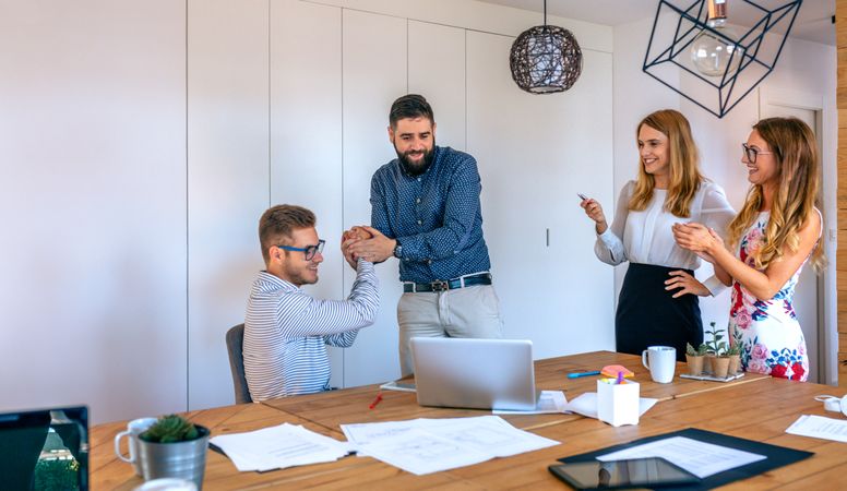 Business people congratulating a coworker on a success