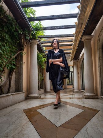 A young woman in a gorgeous dress walks gracefully through the gallery