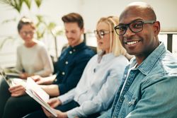 Smiling businessman with on sofa with his colleagues