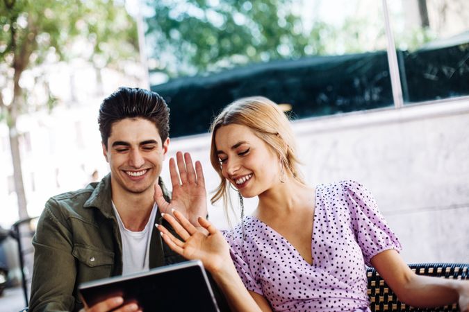 Happy young couple using tablet outdoors