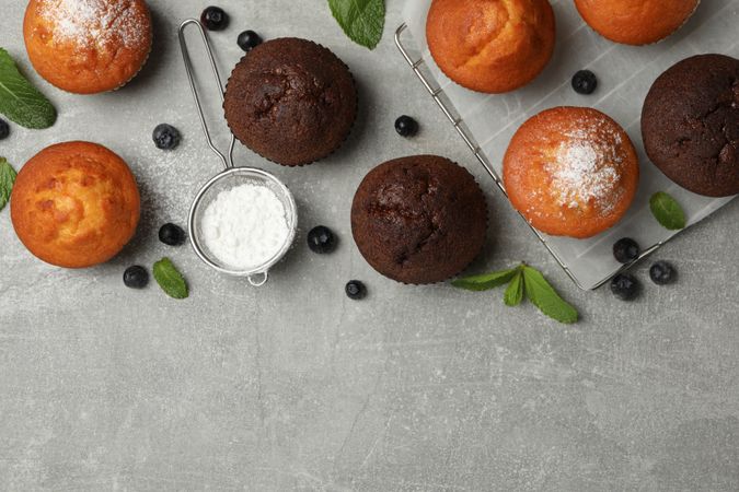 Composition with delicious muffins on gray background, top view