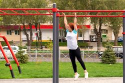 Woman hanging from monkey bars in outdoor