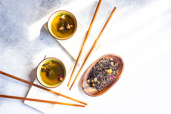 Top view of tea time with two cups of green tea and chopsticks