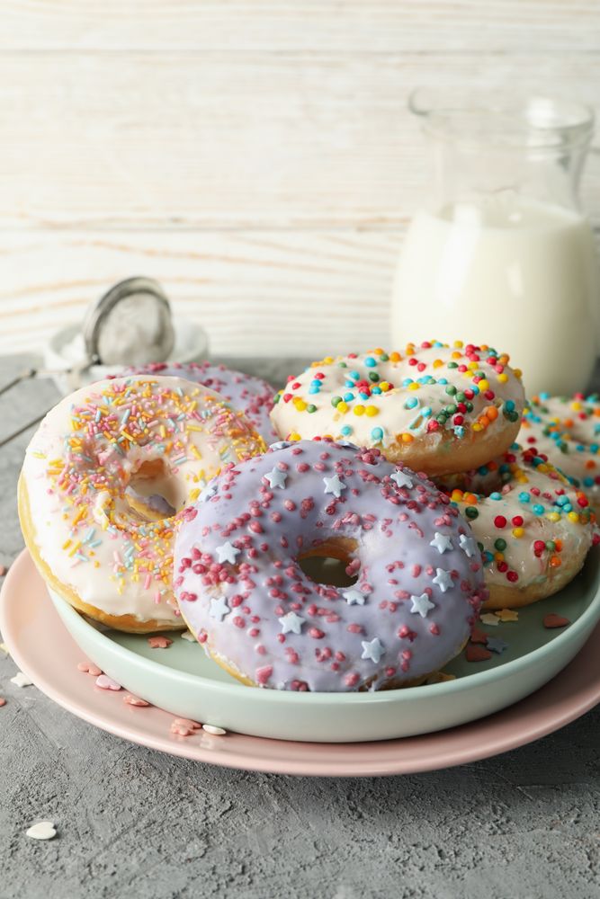 Concept of tasty food with donuts and milk on gray background
