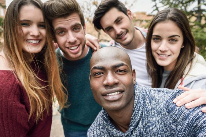 Smiling group of friends looking at camera and posing