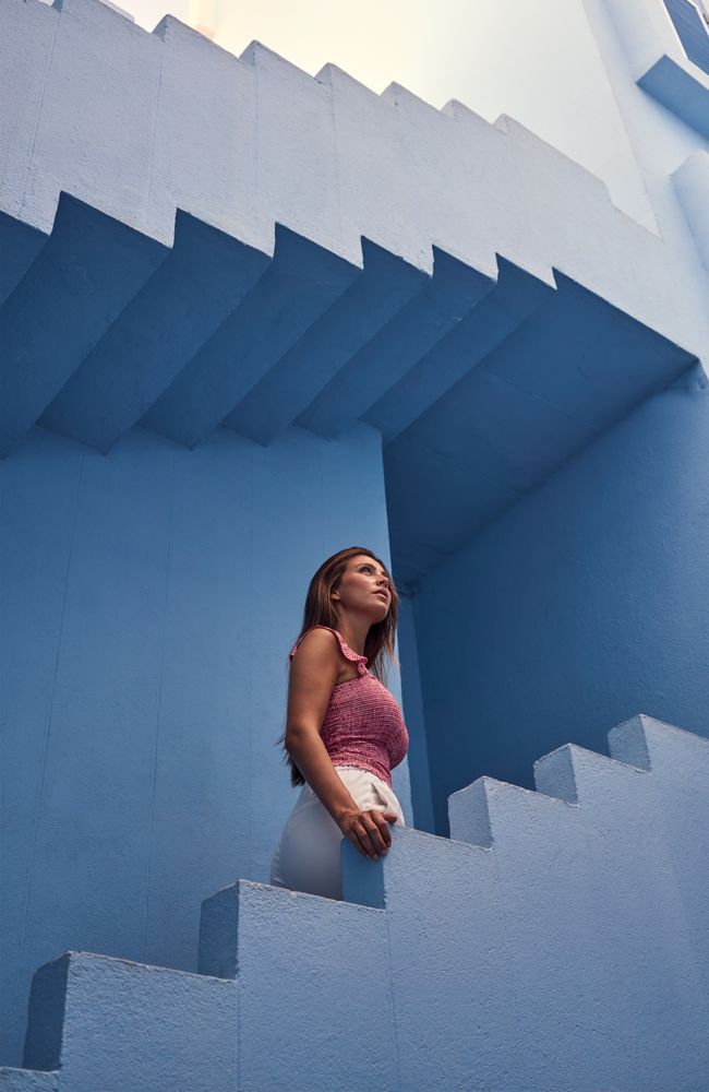 Woman walking upstairs on modern blue building