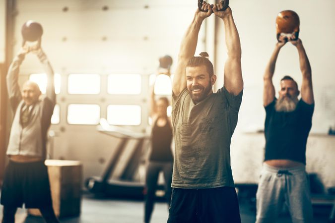 Group of people in weightlifting class with kettlebells