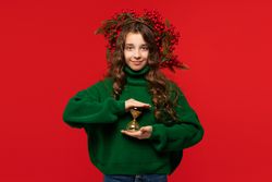 Young girl in green sweater holding golden hourglass
