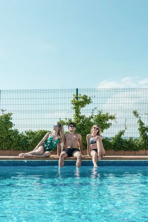 Friends playing with water pistols in the pool