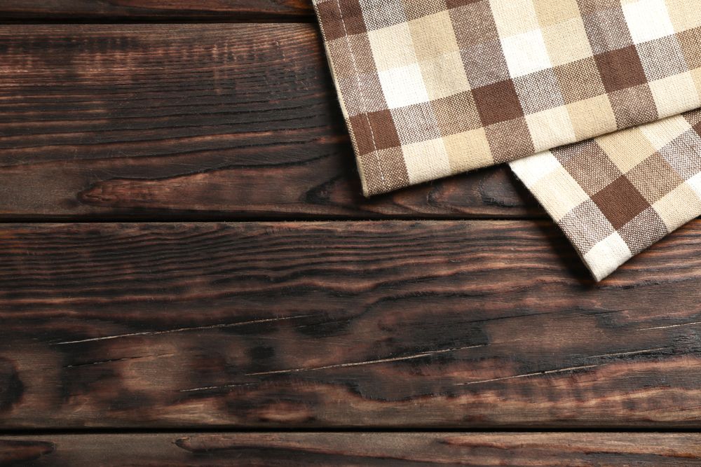 Fabric napkins on wooden background, space for text