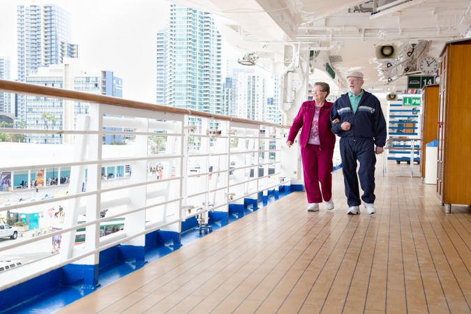 Happy Older Couple Walking The Deck of a Luxury Passenger Cruise Ship.