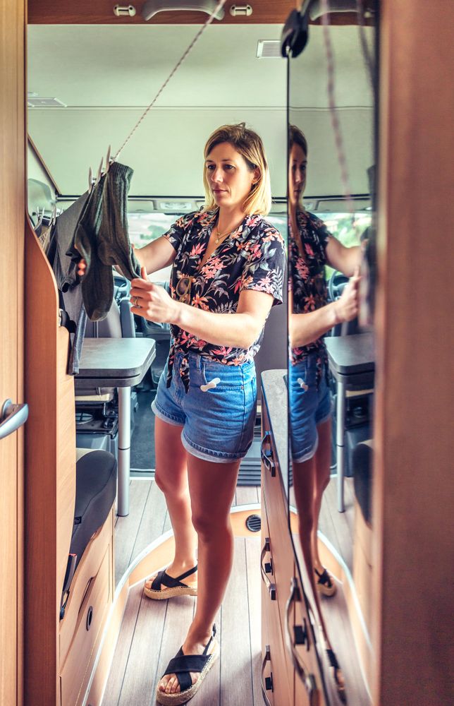 Female uses clothes line inside motorhome, vertical