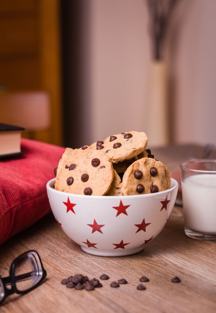 Chocolate chip cookies and milk on wood background