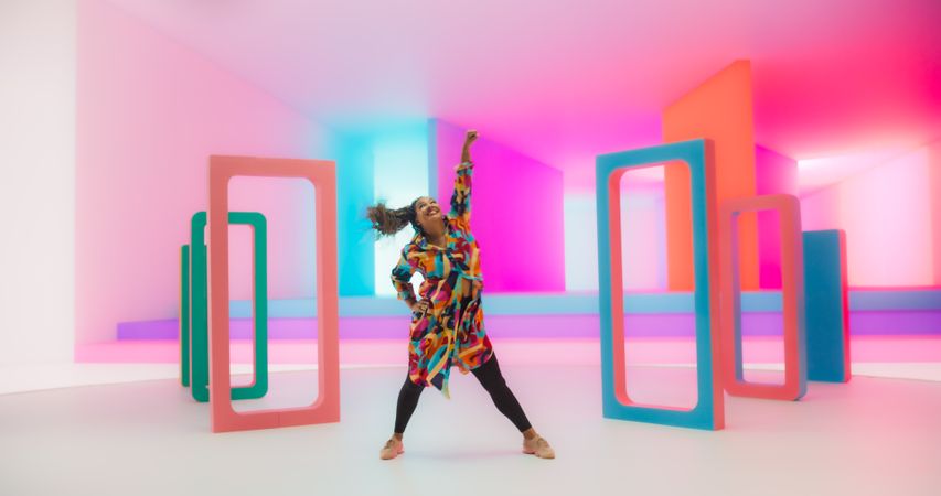 Smiling Black Woman Dancing Energetically in a Colorful Abstract Neon Lit Studio. Talented Stylish Female Dancer Performing a Choreography, Having Fun, Making Moves, Practicing.