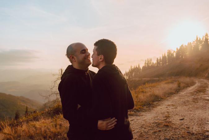 Men hugging and kissing in forest