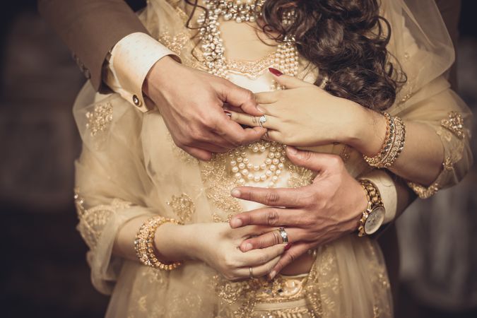 Cropped image of Pakistani bride and groom wearing the wedding ring