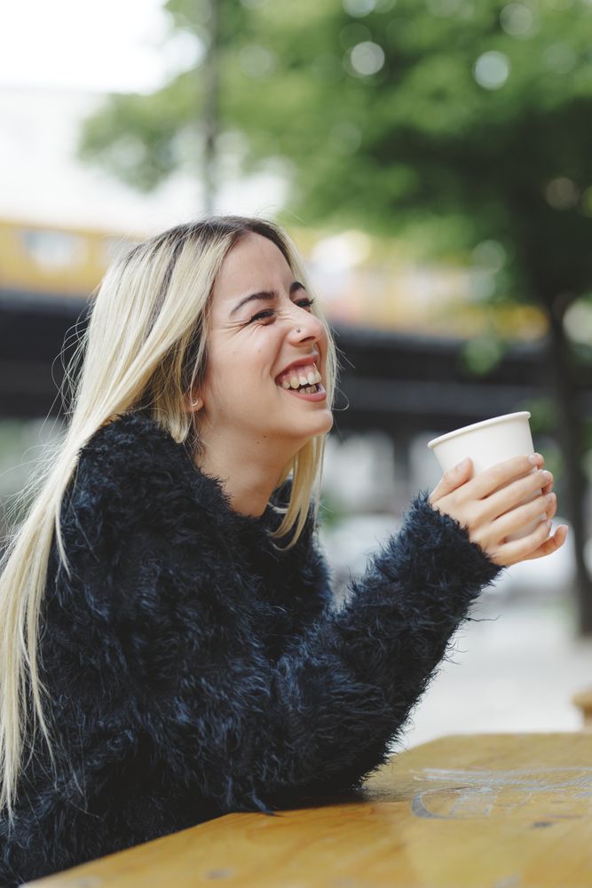 woman drinking coffee in street cafe