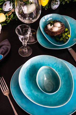 Bright blue plates with decorative eggs on spring themed table