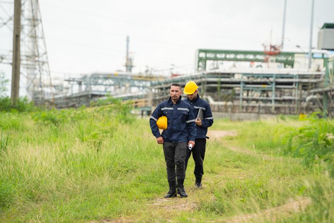 Engineer workers walking and talking to petrochemical industry or refinery oil plant factory.