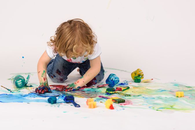 Faceless boy painting on floor